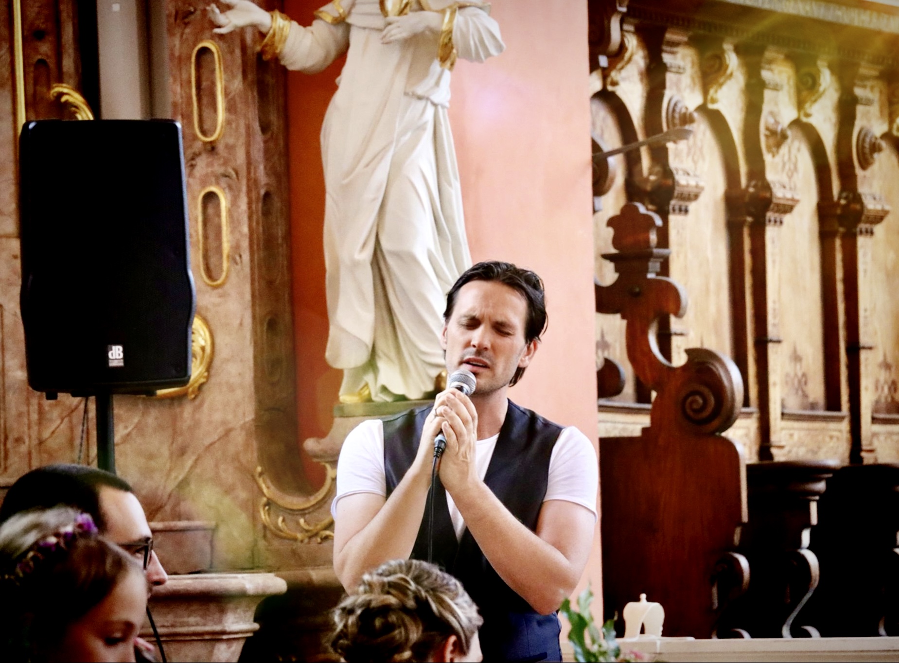Hochzeitssänger Rico Klemm singt mit voller Leidenschaft und geschlossenen Augen ein Lied für das Brautpaar in einer Kirche.