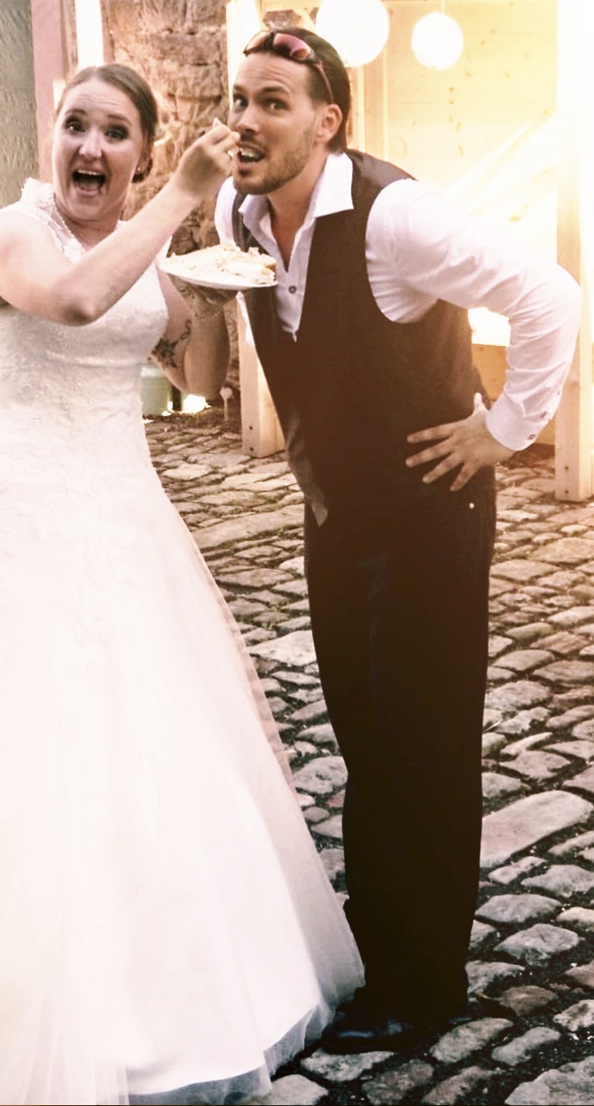 Lustiger Moment auf der Hochzeitsfeier: Die Braut füttert Sänger und DJ Rico Klemm zum Spaß mit einem Stück der Hochzeitstorte.