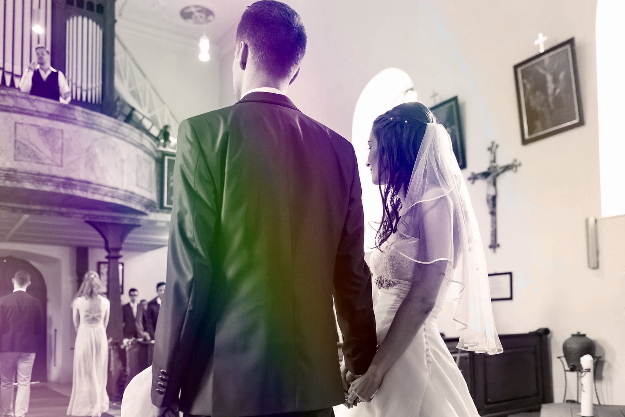 Ein emotionaler Gänsehautmoment: Hochzeitssänger Rico Klemm singt von der Kirchenempore für das Brautpaar, das andächtig vor dem Altar steht.
