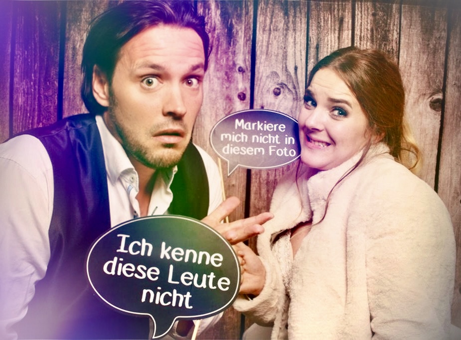 Humorvoller Fotobox-Moment auf einer Feier: DJ Rico Klemm und eine Gästin posieren mit witzigen Sprechblasen für ein lustiges Erinnerungsfoto.