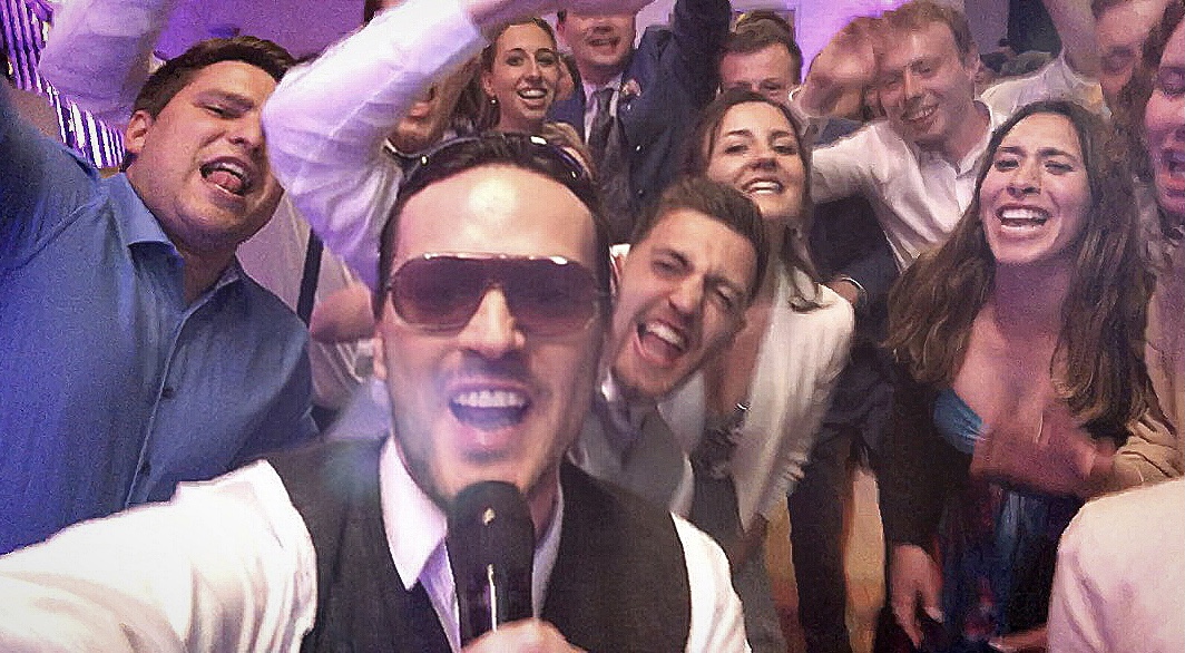 Mitten im Geschehen: Ein cooles Party-Selfie von Sing-DJ Rico Klemm mit Sonnenbrille, umgeben von einer singenden und tanzenden Menge.
