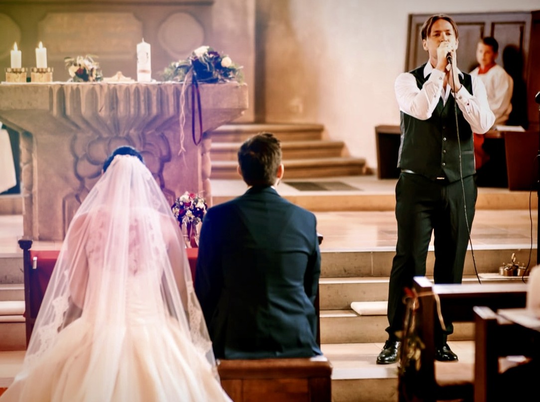 Hochzeitssänger Rico Klemm singt live für das Brautpaar während der kirchlichen Trauung.