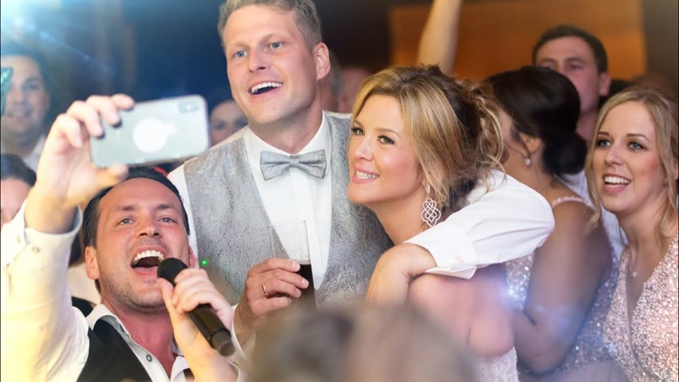 Vorschaubild zum Video: Hochzeitssänger Rico singt neben dem Brautpaar und macht ein Selfie mit den Gästen.